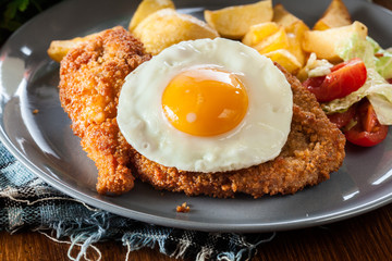Breaded viennese schnitzel with fried agg