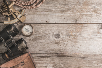 vintage card with compass and others measurement instruments on the wooden timber