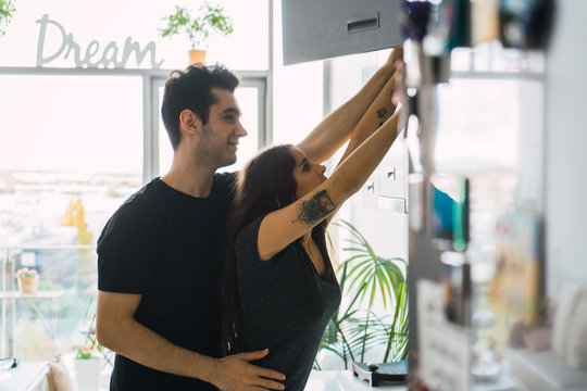 Man Helping To Woman On Kitchen