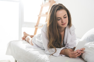 beautiful young woman using smartphone in morning