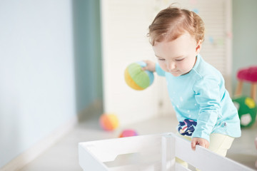 Fototapeta premium little child is playing with toys in the studio