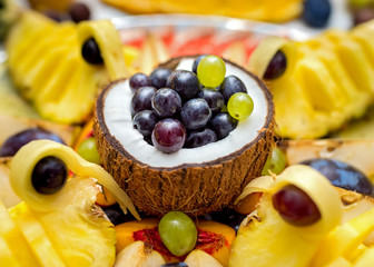 Beautiful arranged fruit, grapes coconuts and pineapple. Fruit mix, fruit table. 