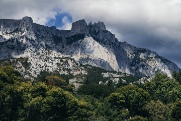 Mount Ai-Petri rises above the forest and the stone tower.