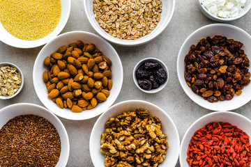 Ingredients of healthy breakfast with superfood on table, seeds, fruits, cereal, nuts, almonds, goji berries, healthy food, flat lay, overhead