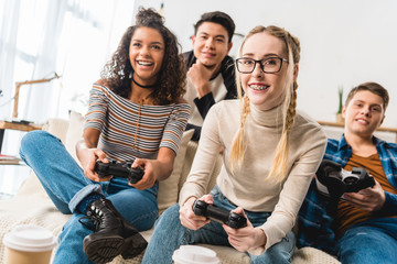 happy teenage multiethnic girls playing video game