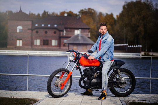 young sports fashionable man on a motorcycle, a warm shot, late autumn