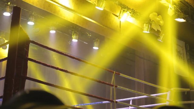 Empty boxing ring with yellow spotlight