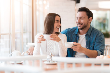 A guy and a girl are sitting together in a cafe.