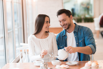A guy and a girl are sitting together in a cafe.