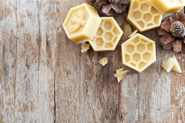 natural yellow beeswax on wooden background. - obrazy, fototapety, plakaty