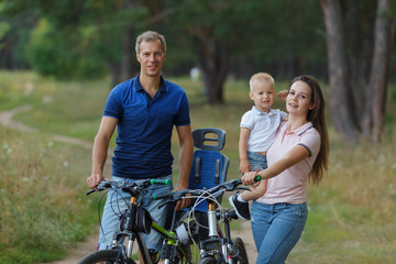 Fototapeta na wymiar Bicyclist family, leisure in pine forest