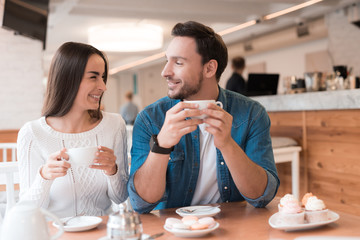 A guy and a girl are sitting together in a cafe.