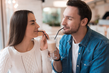 A guy and a girl are sitting together in a cafe.