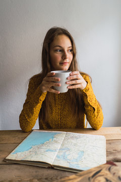 Pretty woman with cup at book
