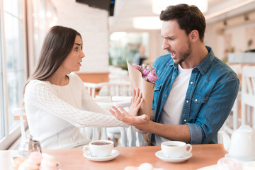 The girl refuses the flowers, which she gives a guy.
