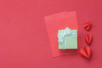 Arrangement decorations Chinese new year & lunar holiday background concept.Beautiful red envelope & ornaments DIY paper fortune cookies on modern rustic wood wallpaper at home office desk studio.