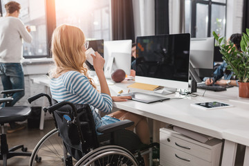incapacitated person in wheelchair working at modern office
