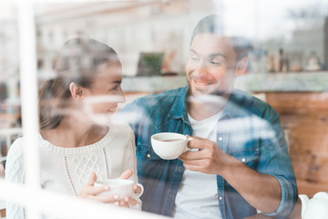 A guy and a girl are sitting together in a cafe.
