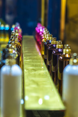 A number of multi-colored perfume bottles with gold spray guns. Background for perfume or jewelry