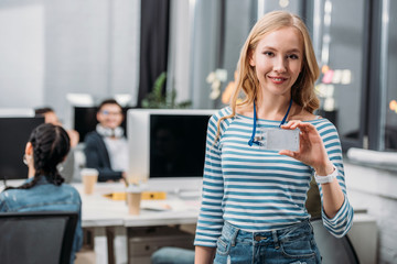young caucasian girl showing name tag at modern office