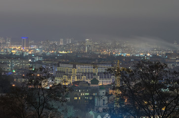 Obraz premium View of the ancient Podil district and modern Obolon district at background. Evening city panorama. Winter weekend evening. Kyiv, Ukraine