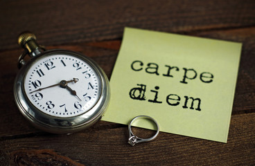 Old pocket watch, ring and note of carpe diem