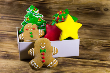Tasty Christmas gingerbread cookies in box on wooden table