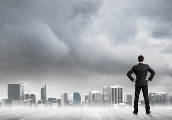 Motivation and inspiration concept with modern cityscape and businessman observing it