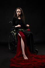 Fototapeta na wymiar Woman sitting on wheel chair on the black background