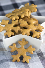 Traditional tasty Czech gingerbreads, Christmas snowflakes in white star shaped bowl on grey chequered tablecloth