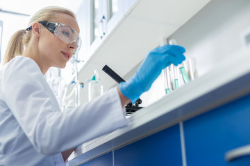 Positive female scientist working in the chemical lab