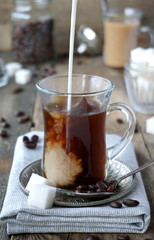 Coffee with milk and sugar in a glass cup