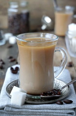 Coffee with milk and sugar in a glass cup