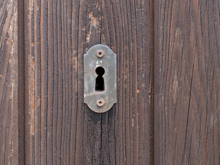 Old door lock on wooden door. Keyhole.