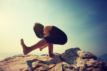 female practicing yoga arm-balance handstand Crane