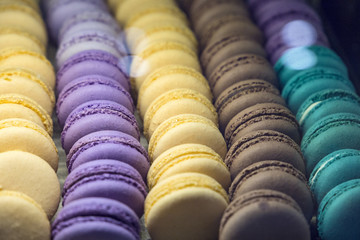 beautiful and tasty multi colored macarons under the shop window of the bakery confectionery shop