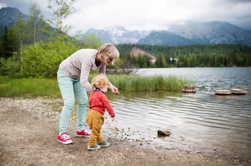 Senior woman with little boy at the lake, summer day.