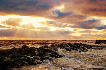 Very colourful sky at night over a raging sea