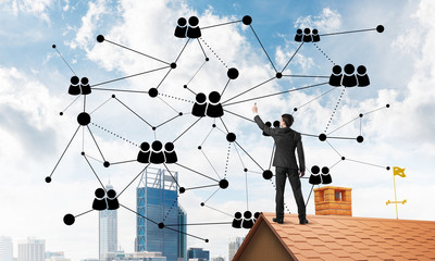 Businessman on house roof presenting networking and connection concept. Mixed media