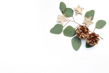 Christmas festive styled stock image. Floral frame composition with pine cones, eucalyptus branches and birch wooden stars on white wooden background. Flat lay, top view. Empty copy space. © tabitazn