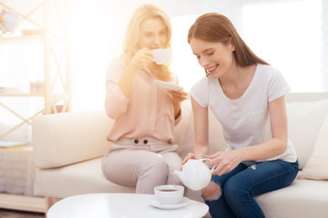 Obraz na płótnie Canvas Mom and daughter-teen drink tea.