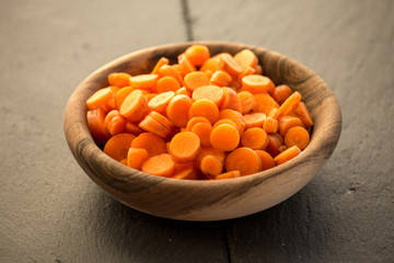 Carrot slices in wooden bowl.