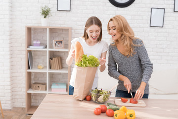 Mom and daughter are cooking together in the kitchen.