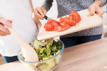 Mom and daughter are cooking together in the kitchen.