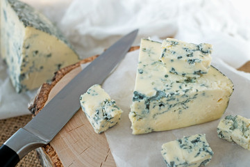 Tasty blue cheese on a wooden background. Dorblu cheese pieces