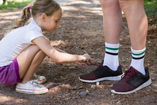 Girl tying her grandfathers shoe laces