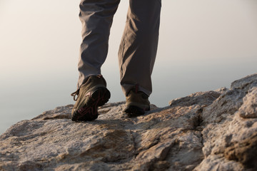 hiker legs standing on windy coast cliff edge