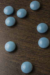 Heap of blue pills capsule on wooden table