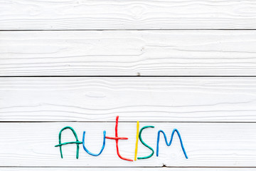 Childhood diseases. Word autism on white wooden background top view copyspace