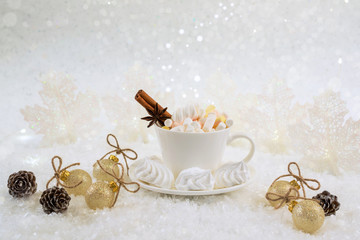Obraz na płótnie Canvas Cup of hot beverage with marshmallow and spices on snow background.
